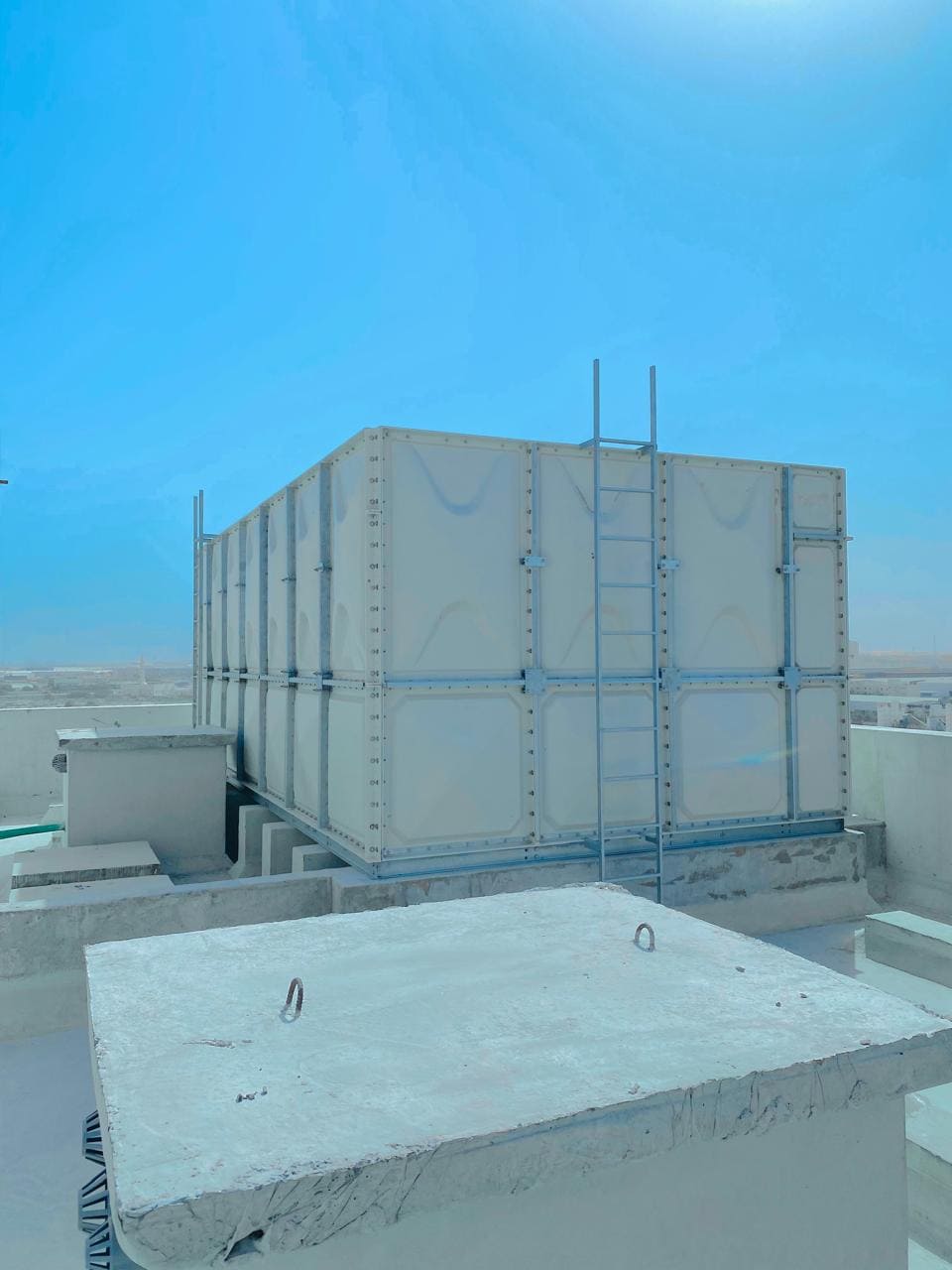 ZISIF GRP tank on a rooftop with concrete plinth